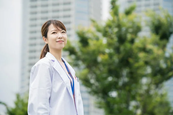 身穿白衣 摆出室外姿势的亚洲女保健工作者 — 图库照片