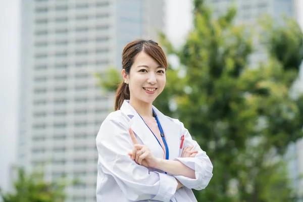 Beyaz Önlüklü Dışarıda Poz Veren Asyalı Kadın Sağlık Görevlisi — Stok fotoğraf