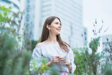 Parkta rahat bir ifadeyle yürüyen genç bir kadın.