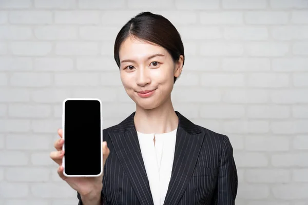 Takım Elbiseli Asyalı Genç Kadını Akıllı Telefon Ekranı Kullanıyor — Stok fotoğraf