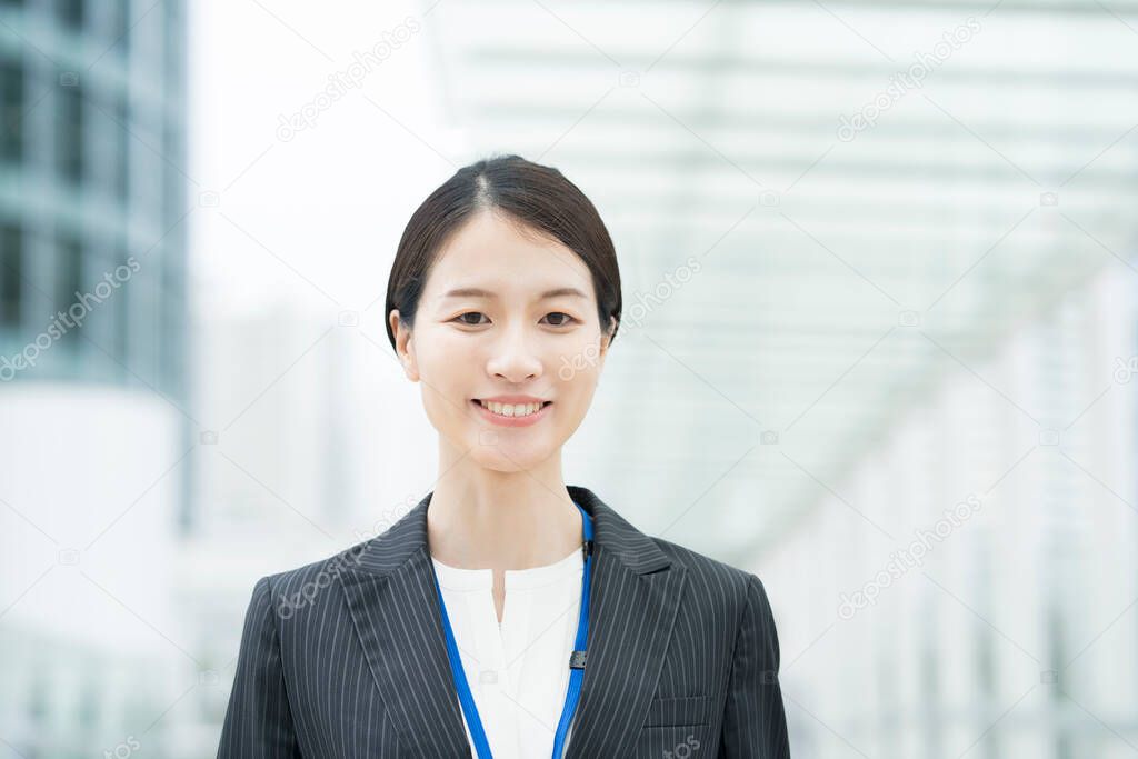 Portrait of a smiling Asian young business woman wearing a suit