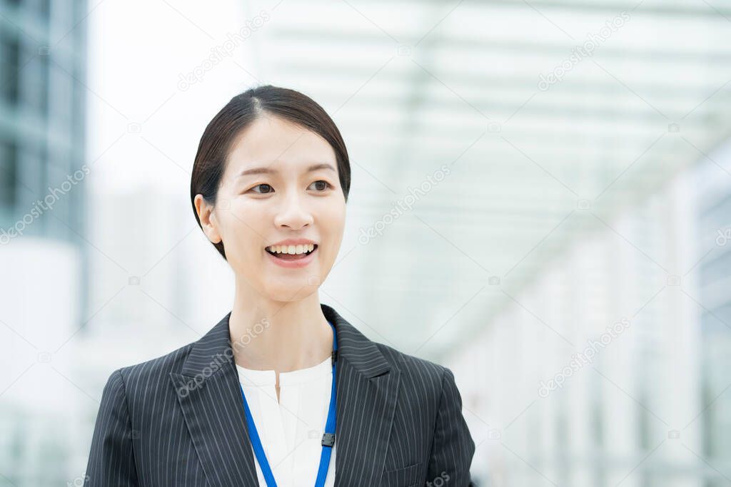 Portrait of a smiling Asian young business woman wearing a suit