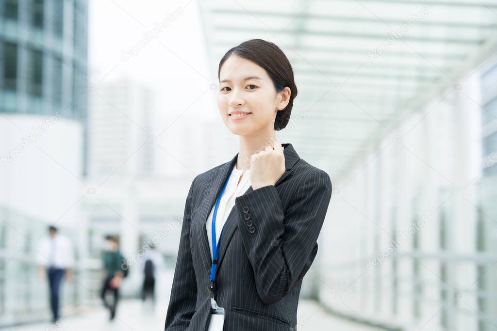 Asian young business woman in a suit posing with a smile and cheering