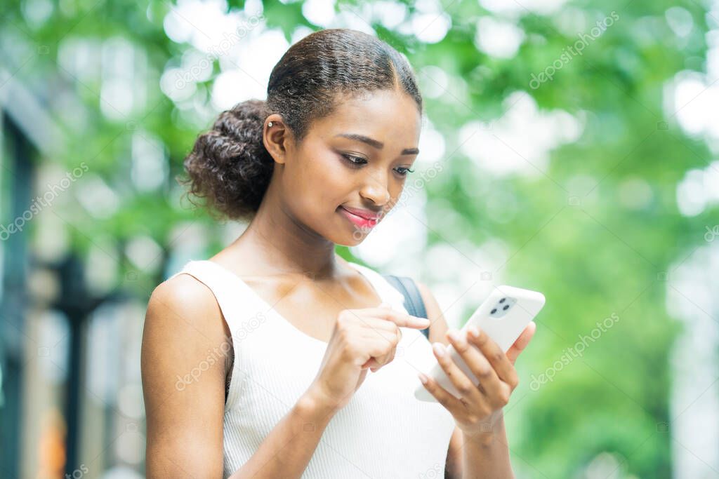 Young business woman operating by looking at the screen of the smartphone