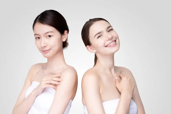 Caucasian and Asian young women line up wearing white off-shoulder tops