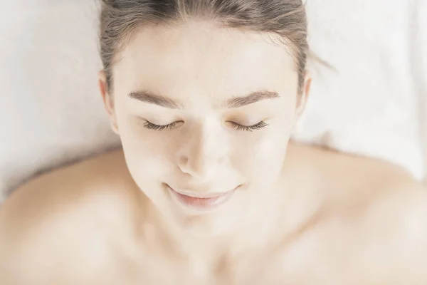 Relaxed face of young woman lying down in beauty salon