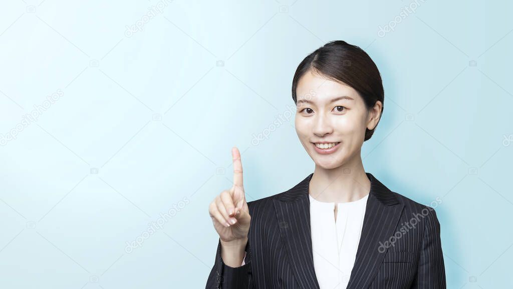 Portrait of Asian young business woman posing with pointing finger