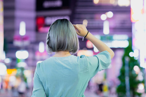 Young woman posing in the glowing cityscape of Tokyo at night