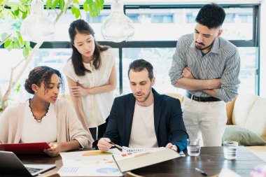 Çeşitli ırklardan iş adamları sıradan bir ofiste toplanıyor.