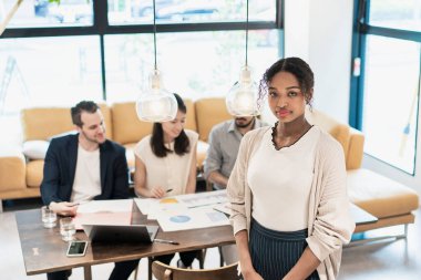 Ofiste poz veren bir iş kadınıyla uluslararası iş ekibi.