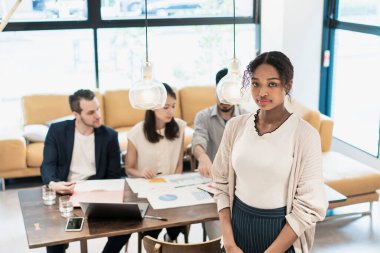 Ofiste poz veren bir iş kadınıyla uluslararası iş ekibi.