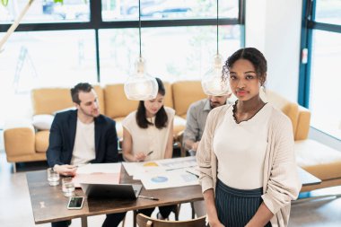 Ofiste poz veren bir iş kadınıyla uluslararası iş ekibi.