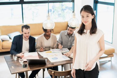 Ofiste poz veren bir iş kadınıyla uluslararası iş ekibi.