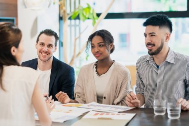Çeşitli ırklardan iş adamları sıradan bir ofiste toplanıyor.