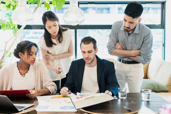 Çeşitli ırklardan iş adamları sıradan bir ofiste toplanıyor.