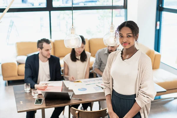 Ofiste poz veren bir iş kadınıyla uluslararası iş ekibi.