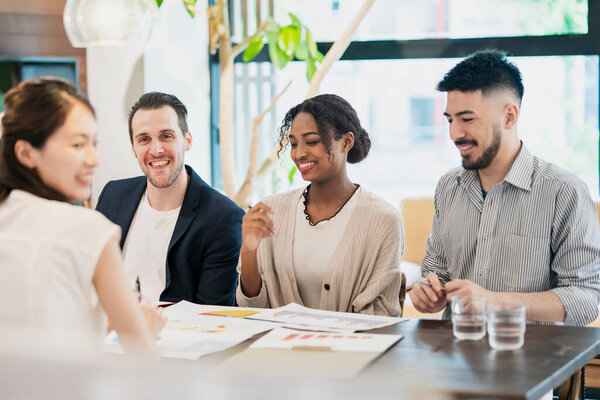 Бизнесмены различных рас встречаются в неформальном офисном пространстве