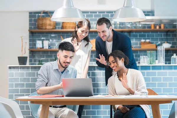 Businessmen waving their hands toward the PC screen and greeting