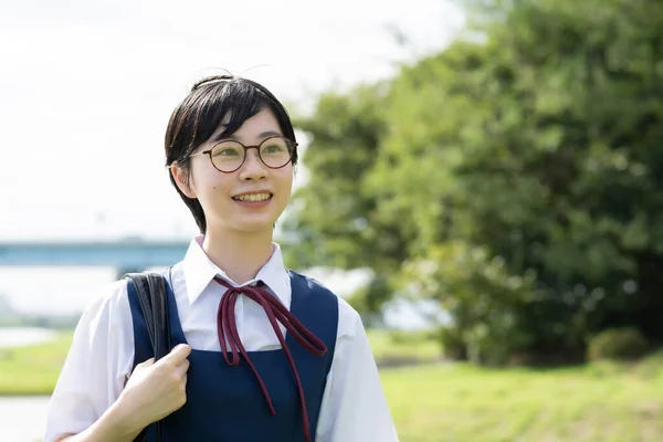 Asian high school girls wearing uniforms and smiling at school