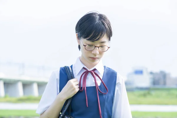 Asian high school girl with short black hair wearing glasses