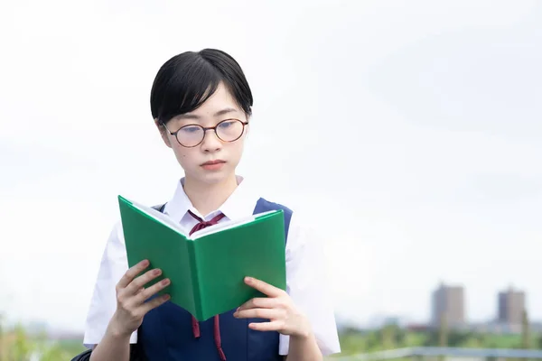 Asyalı Liseli Kız Ciddi Bir Ifadeyle Kitap Okuyor — Stok fotoğraf