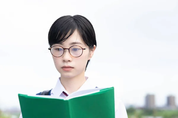Asyalı Liseli Kız Ciddi Bir Ifadeyle Kitap Okuyor — Stok fotoğraf