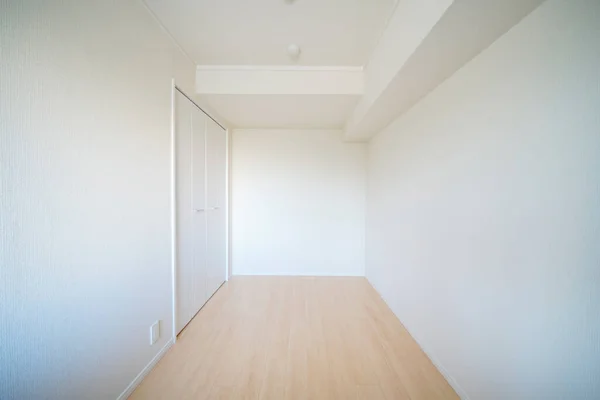 residence room with storage space, white wall and wood floor