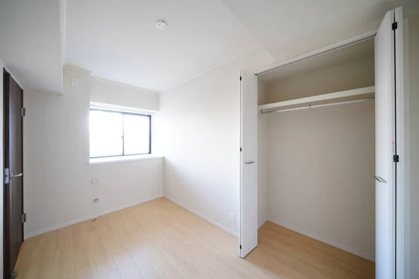 residence room with storage space, white wall and wood floor