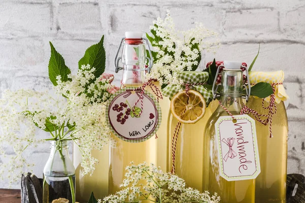 Διαφορετικά Μπουκάλια Σπιτικό Σιρόπι Elderflower Μπροστά Από Έναν Λευκό Τοίχο — Φωτογραφία Αρχείου