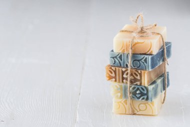 Beyaz ahşap üzerinde çeşitli doğal sabun kalıpları. Fotokopi alanı olan stok fotoğrafı.