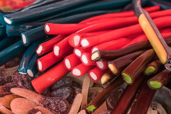 Red, brown and black licorice canes on a market stand