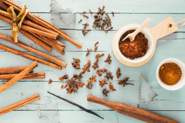 Tarçın gibi baharatlar pişirmek, yıldız anason ve açık mavi ahşap masa üzerinde kakao, Noel kurabiyesi makasıyla süslenmiş. Üst görünüm.