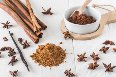 Tarçın gibi baharatlar, beyaz ahşap masa üzerinde yıldız anason ve kakao.
