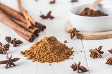 Tarçın gibi baharatlar, beyaz ahşap masa üzerinde yıldız anason ve kakao.