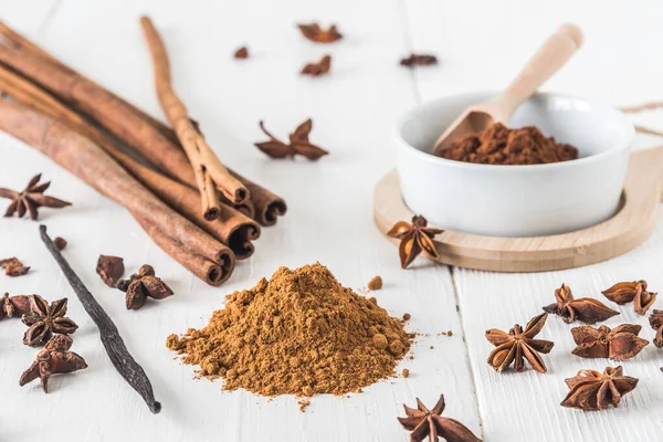 Tarçın gibi baharatlar, beyaz ahşap masa üzerinde yıldız anason ve kakao.