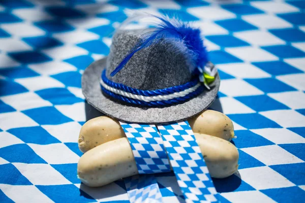 white sausages on blue white background with traditional hat, funny background for Oktoberfest