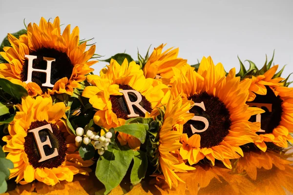 带字母的向日葵 黄色背景 — 图库照片