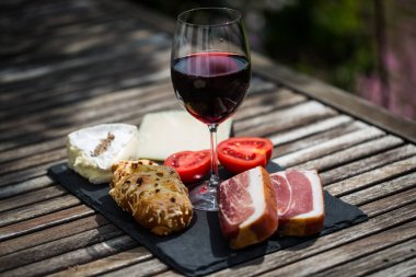 Wine, cheese and bacon on slate