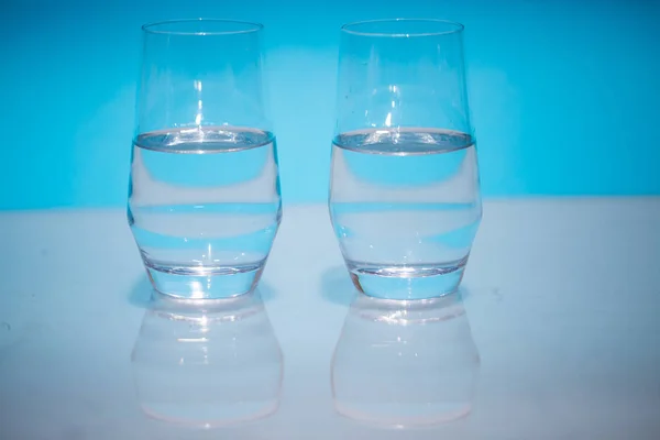 Halfvolle water bril, twee halflege water glazen tegen een — Stockfoto
