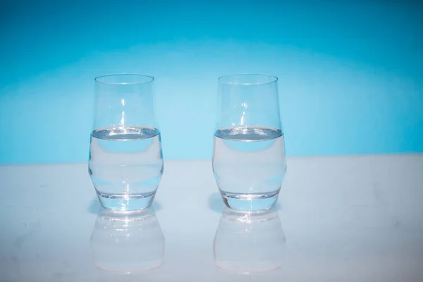 Half-full water glasses, two half-empty water glasses against a