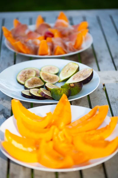 Melón con jamón de parma y un plato de higos frescos — Foto de Stock