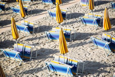 katlanmış plaj sandalye ve şemsiye ile boş plaj