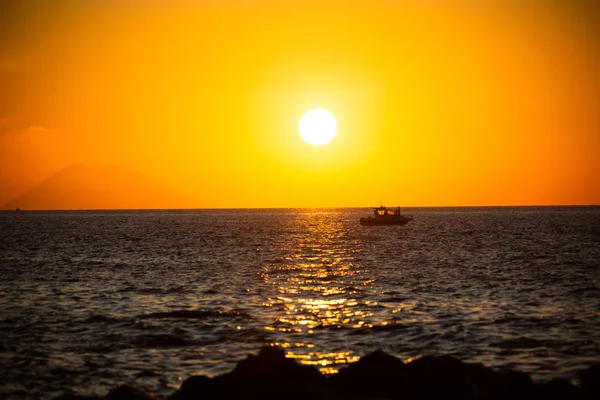 Стромболі і рибальський човен на заході сонця з Тропеа — стокове фото