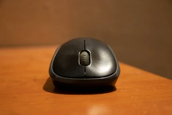 computer mouse close up,black color mouse on wooden table,selective focus ,focus on subject