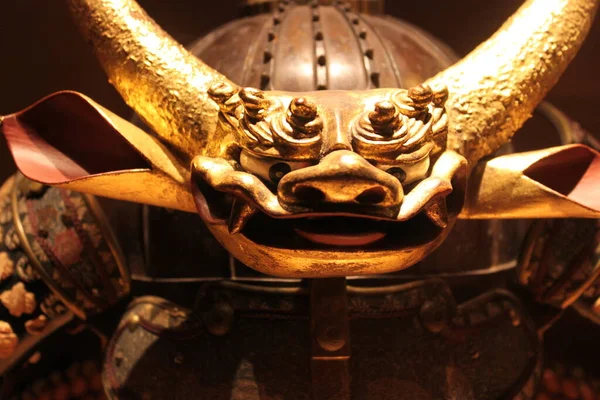 東京の武家博物館に展示されている劇的な照明で古代の武士の龍のシンボルマークのヘルメット — ストック写真