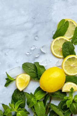 Limon dilimleri, nane yaprağı ve buz küpleriyle yaz kompozisyonu. Minimum limonata içeceği konsepti. Üst görünüm