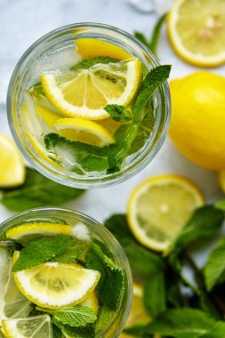 Yaz için ferahlatıcı içecekler, dilimlenmiş taze limonlu soğuk tatlı ve ekşi limonata suyu. Tazeleyici yaz içeceği. Limonlu, naneli ve buzlu geleneksel limonata. Seçici odak