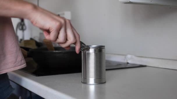 Una mujer en la cocina abre una lata . — Vídeo de stock