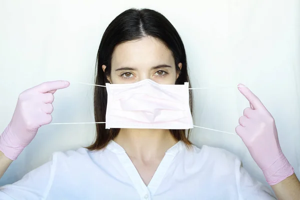 Woman Pink Gloves Puts Pink Protective Mask Girl Stands Light — Stock Photo, Image