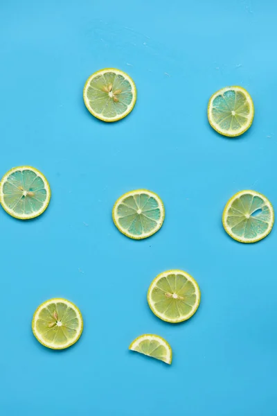 Composition with cut citrus fruits on blue background. Creative summer background composition with lemon slices. Minimal top down lemonade drink concept.Top view